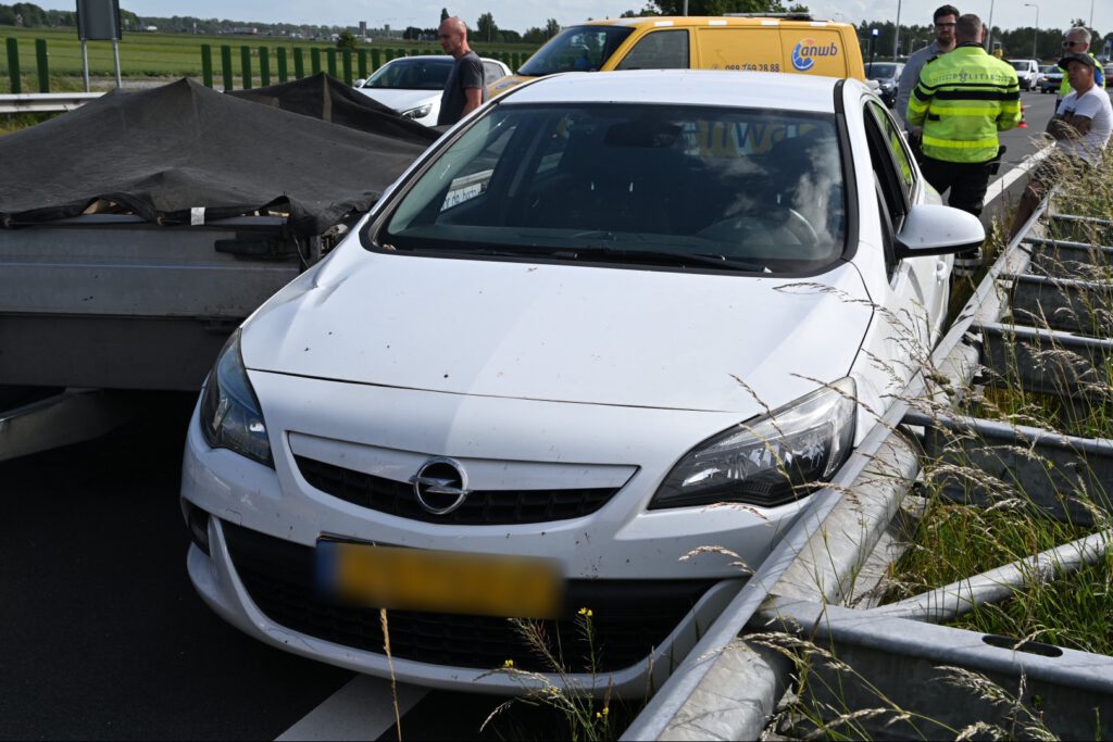 Auto tussen vangrail gedrukt door bedrijfsbusje [FOTO'S]