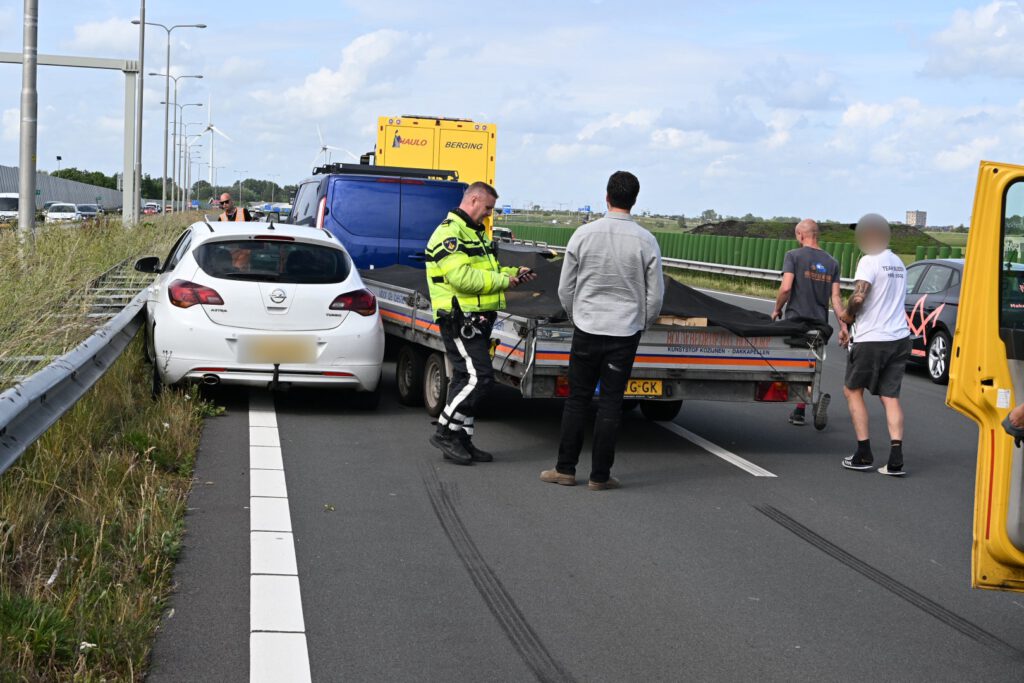 Auto tussen vangrail gedrukt door bedrijfsbusje [FOTO'S]