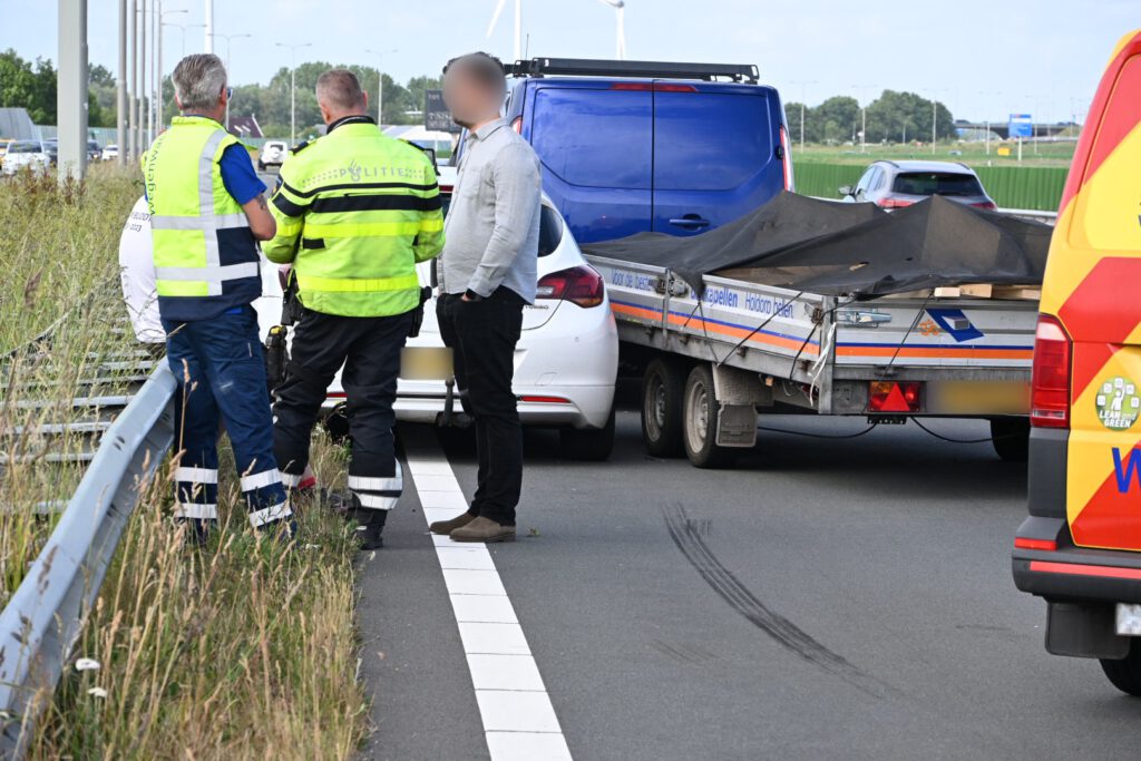 Auto tussen vangrail gedrukt door bedrijfsbusje [FOTO'S]