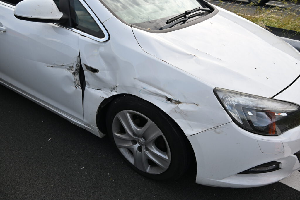 Auto tussen vangrail gedrukt door bedrijfsbusje [FOTO'S]