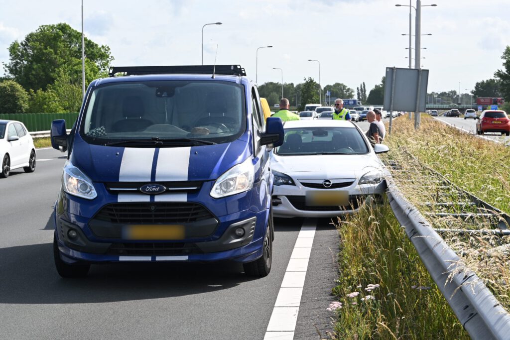 Auto tussen vangrail gedrukt door bedrijfsbusje [FOTO'S]